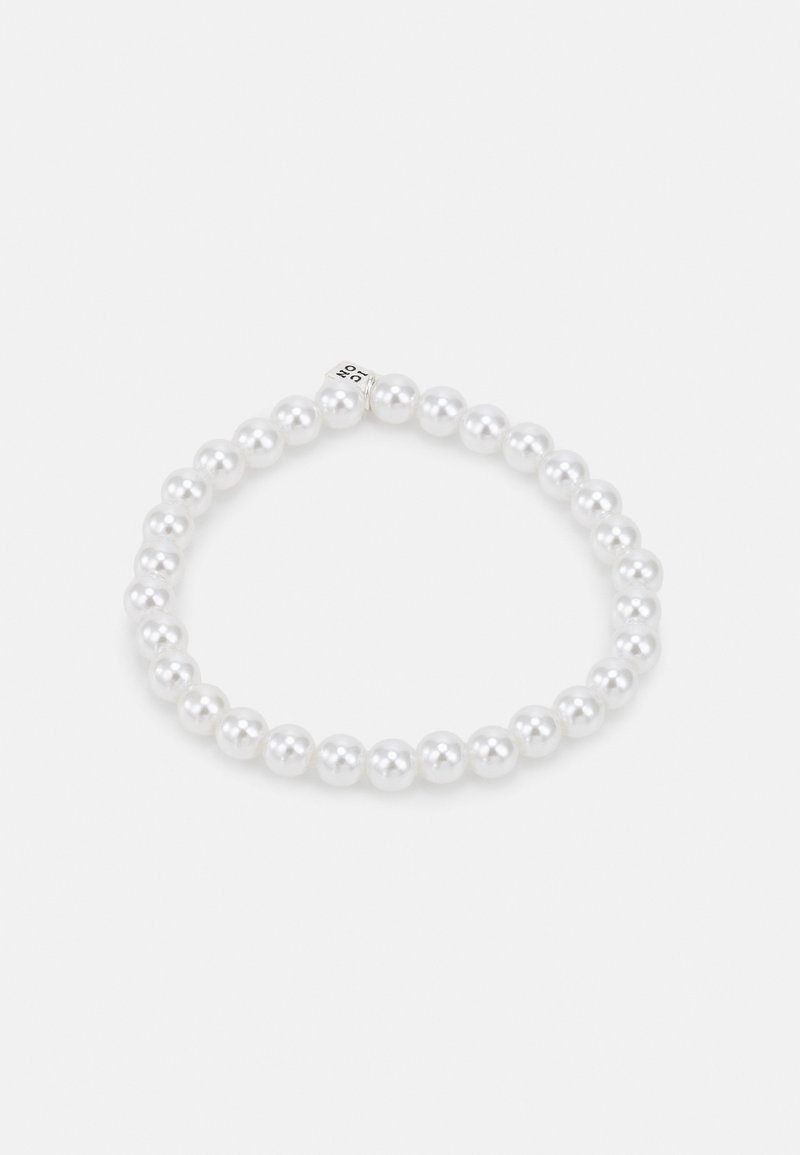 Elastisk armbånd laget av ensartede hvite perler, med en glatt, blank finish. Et diskret design med en sikker lukking i sølvperle.