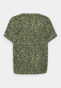 Haut à manches courtes en vert foncé, présentant un motif floral dispersé en jaune, rose et noir. Tissu doux, coupe décontractée, col rond.