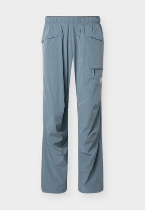 Ανοιχτόμπλε παντελόνι εξωτερικού χώρου με ελαστική μέση και τσέπη με φερμουάρ στο δεξί μπούτι, σχεδιασμένο για πεζοπορία ή ενεργή χρήση.