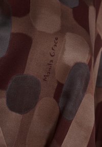 Tissu transparent avec un motif abstrait de grands cercles superposés dans des nuances de marron, de gris et de bordeaux, présentant une subtile signature de marque.