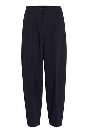 Pantalons plissés bleu marine avec une taille haute, présentant une coupe ample et des chevilles fuselées. Texture lisse et design minimaliste.