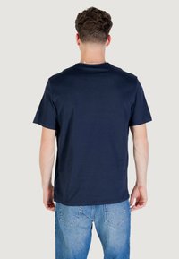T-shirt di cotone blu navy con maniche corte e scollo tondo, mostrata di spalle con vestibilità rilassata e orlo dritto.