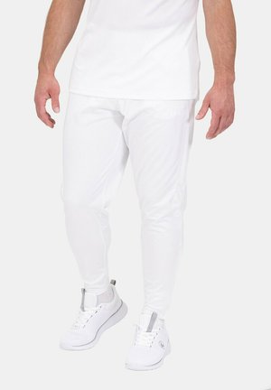 Weiße Sporthosen mit schlanker Passform, aus dehnbarem Stoff gefertigt, kombiniert mit passenden weißen Sneakers mit grauen Akzenten.