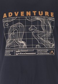 Carte topographique avec courbes de niveau, grille, échelle, et le mot "AVENTURE" en haut ; le texte indique "Explorer la nature sauvage à Whistler, c'est là que l'aventure commence."