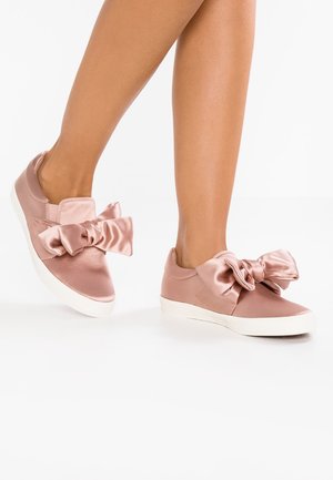 Roze satijnen sneakers met grote strikken aan de zijkanten, witte rubberen zolen en een instapontwerp voor gemakkelijke draagbaarheid. Gladde textuur en slanke vorm.