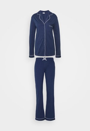 Navy blue pajama set made of soft fabric; button-up top with white piping, long sleeves, and matching pants with an elastic waistband and drawstring.