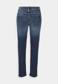Jeans de mezclilla azul oscuro con corte recto, bolsillos traseros con costura y una etiqueta de cuero en la cinturilla.