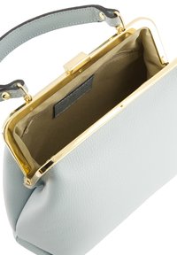Sac à main en cuir bleu clair avec un cadre et un fermoir en métal doré. Intérieur doublé de tissu marron, avec une petite poche. Texture lisse.