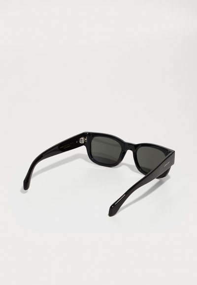 Schwarze Sonnenbrille mit glänzender Oberfläche, rechteckiger Form, grauen Gläsern und massiven schwarzen Bügeln, die ein Logo an der Seite tragen.