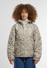 Bieza kamuflāžas jaka ar bežiem un gaiši brūniem rakstiem, ar kapuci, priekšējo rāvējslēdzēju un divām priekšējām kabatām. Mīksta tekstūra.