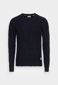 Granatowy sweter robiony na drutach z teksturowanym wzorem, okrągłym dekoltem i ściągaczami przy mankietach i u dołu. Posiada małą metkę po boku.
