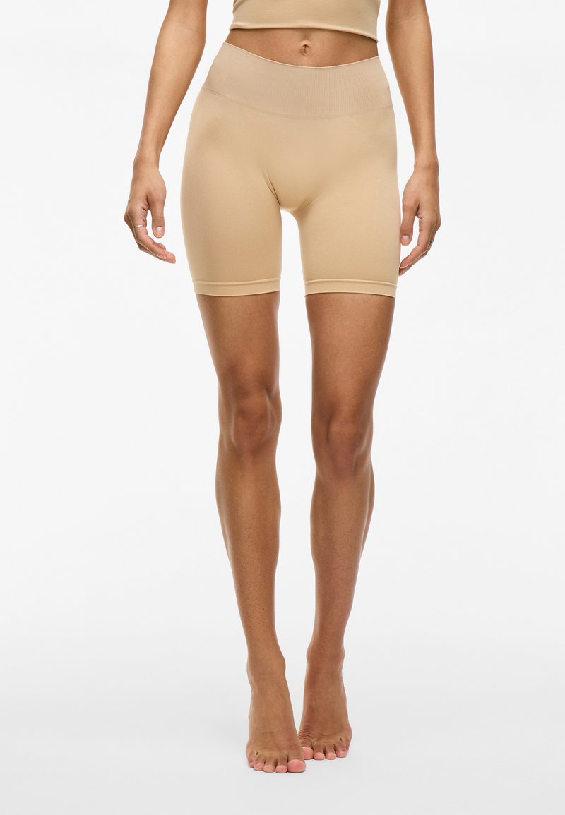 Beige strakke shorts met een hoge tailleband, gemaakt van een gladde stof, met een naadloos ontwerp en een lengte tot halverwege de dij.