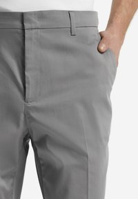 Grå skräddarsydda byxor med en jämn textur och ren design, med sidofickor och slät front för en modern passform.