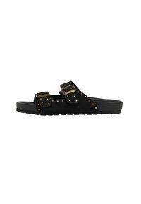 Sandal in camoscio nero con doppie cinghie e borchie dorate. Presenta una suola in gomma piatta e un hardware decorativo con fibbia.