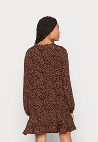 Vestido castanho escuro com estampado de leopardo preto, apresentando mangas longas, gola arredondada e uma bainha com babados na parte inferior.