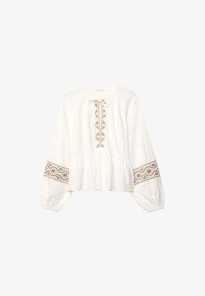 Witte katoenen blouse met lange mouwen, met een textuurstof, voorzien van bruine geborduurde patronen langs de halslijn en manchetten, en een striksluiting.