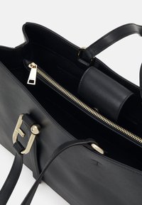 Sac à main en cuir noir avec fermeture éclair, quincaillerie dorée et poche latérale. Texture lisse et design structuré avec une bandoulière détachable.