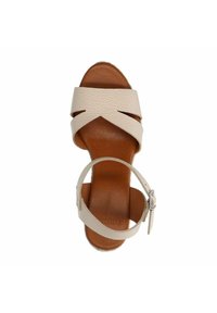 Beige Leder-Sandale mit überkreuzten Riemen und einem schmalen Knöchelriemen, ausgestattet mit einer braunen strukturierten Innensohle und einer glatten Sohle.