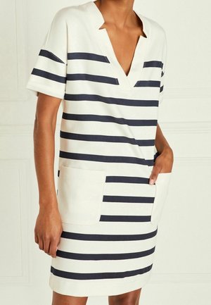 Vestido de rayas en crema y azul marino con escote en V, manga corta y dos bolsillos frontales. Tela suave con un corte relajado.