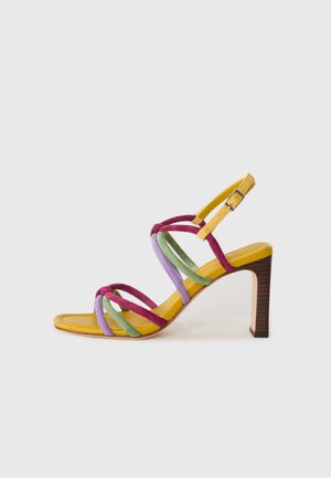 Sandale à talon multicolore avec des brides en suède violettes, vertes et bourgognes, semelle intérieure jaune et talon texturé marron.