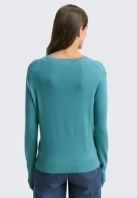 Pullover in Türkis, aus weichem Strickmaterial gefertigt. Verfügt über lange Ärmel und einen gerippten Saum, mit einem abgerundeten Ausschnitt und sauberen Nähten.