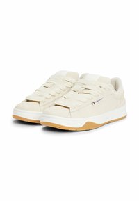 Baskets en daim beige avec de larges lacets assortis, semelle intermédiaire blanche et semelle extérieure en gomme. Présente un petit logo sur le côté.