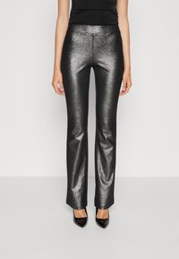 Zwarte, metalen flared broeken met een glanzende, textuurrijke afwerking. Heeft een fitted taille en een soepele silhouet, gecombineerd met puntige zwarte hakken.