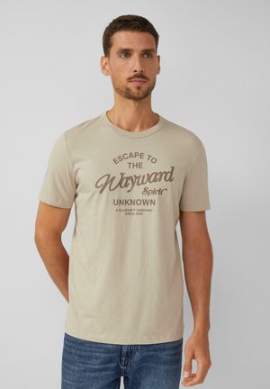 Beige katoenen t-shirt met een ronde hals en korte mouwen, voorzien van bruine tekst in een retro lettertype, met de tekst "Escape to the Wayward Spirit."