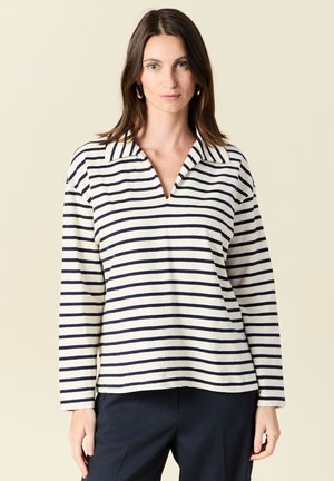 Gestreepte pullover in crème en marineblauw, met een gesneden kraag, lange mouwen en een ontspannen pasvorm. Zachte textuur met horizontale strepen.