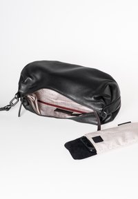 Schwarze Leder-Clutch mit strukturierter Oberfläche, offener Reißverschluss, der ein helles Innenfutter zeigt, und einem kleinen Handyfach daneben.