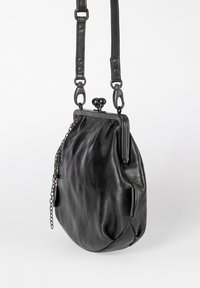 Schwarze Leder-Umhängetasche mit einem runden Verschlussrahmen, verstellbarem Riemen und dekorativem Kettendetail vor weißem Hintergrund.