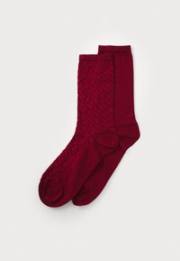 Burgunderfarbene Socken mit einem strukturierten, gewebten Muster auf einer und einer glatten Oberfläche auf der anderen. Beide haben eine standardmäßige Crew-Länge.