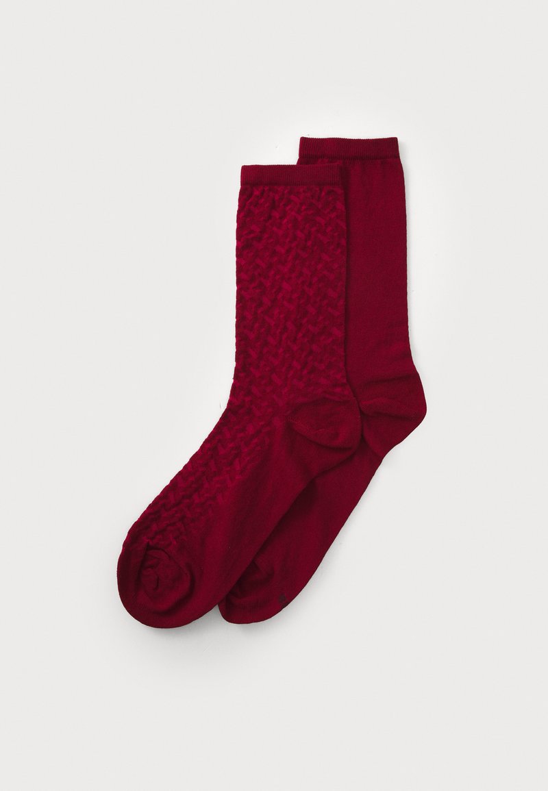 Burgundy socks with a textured, woven pattern on one and a smooth finish on the other. Both feature a standard crew length.