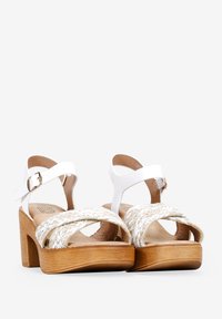 Sandales blanches à lanières avec un détail en corde tressée à l'avant, dotées d'un talon en bois et d'une sangle à boucle à la cheville.