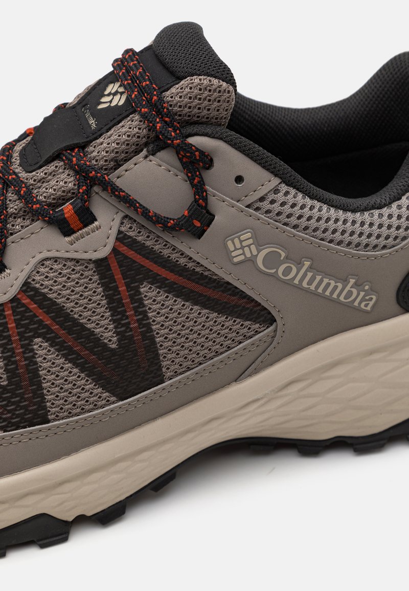 Columbia Wanderschuh mit grauem Mesh-Obermaterial und orangen Akzenten, strukturiertem Gummisohle und schwarzem Schnürsenkel für einen sicheren Halt und Flexibilität.