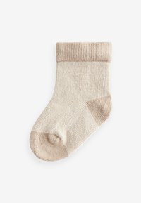 Beige strikket sok med en ribbet kant, der har en blød tekstur og et glat fodområde. Ingen mønstre eller dekorationer synlige.