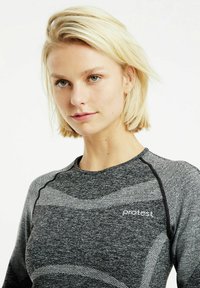 Graues sportliches Oberteil mit gemustertem Textil, das schwarze Akzente und einen runden Halsausschnitt aufweist. Die Marke "Protest" ist auf der Brust sichtbar.
