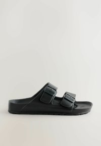 Sorte slidssandaler lavet af gummi med en tekstureret overflade, to justerbare remme med spænder og en flad, formet sål.