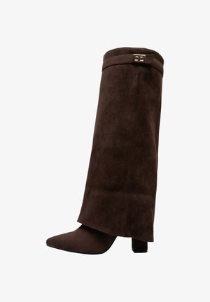 Bottine en suède marron avec un bout pointu, un petit talon carré et un design à revers avec une accent en boucle en ton doré.