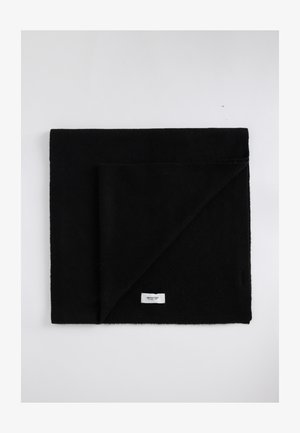 Zwarte deken van zacht, textuurstof, gevouwen in één hoek. Heeft een klein wit label aan de onderrand.
