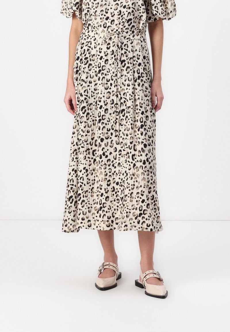Leopardmønstrete midi-kjole med plisserte detaljer, knyttet midje og korte puffy-ermer. Kombinert med beige sko med reim og spenne.
