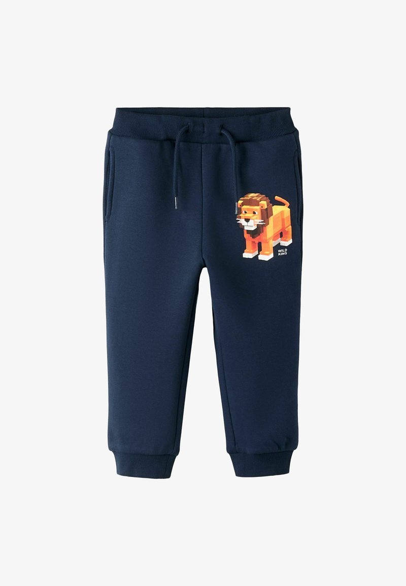 Marineblå joggebukser med elastisk midjebånd og snor, med et pixelert løvegrafikk på venstre lår. To sidelommer.