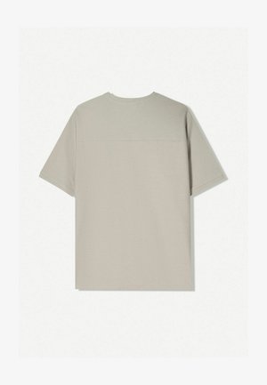 Tricou din bumbac bej cu mâneci scurte. Are un design simplu și un guler rotund. Textura netedă cu cusături minime pe spate.