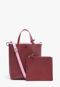 Sac fourre-tout en cuir bordeaux avec poignées roses et bandoulière, accompagné d'une pochette zippée bordeaux assortie.