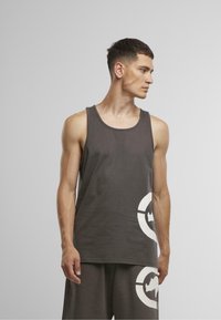 Gray cotton tank top with a round neckline, featuring a large white graphic design on the lower side. Soft texture and casual fit.