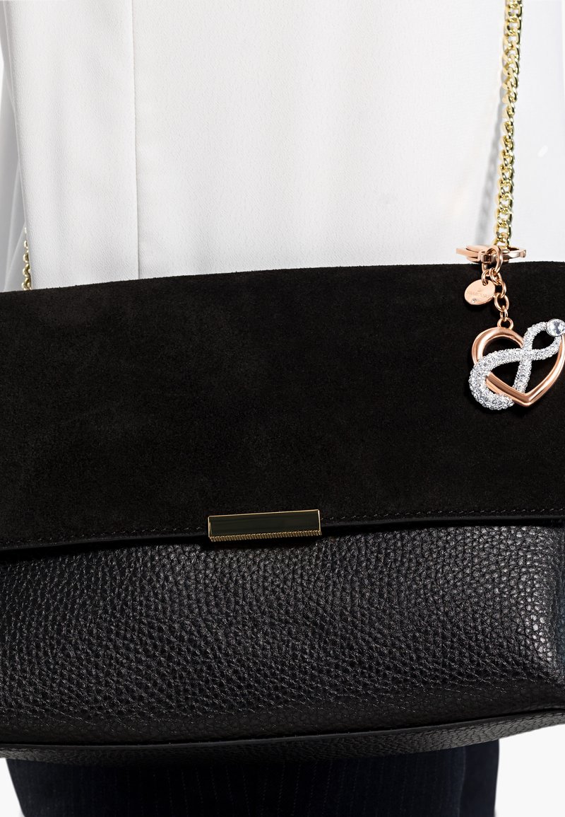 Borsa nera con fondo in pelle testurizzata e parte superiore in morbido suede. Manico a catena dorata e charm con un design a cuore e simbolo dell'infinito.