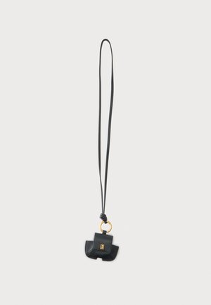 Mini bolso negro de cuero con herrajes dorados en una larga correa negra, diseñado para llevarse alrededor del cuello.