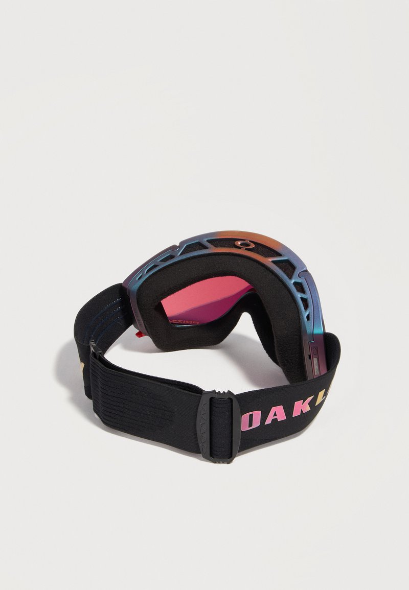 Gafas de esquí con lentes reflectantes rosas, almohadillas de espuma negras y una correa ajustable negra con la palabra "OAKLEY" en letras multicolores.