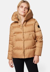 Khaki puchowy kurtka o grubej, izolującej konstrukcji, z dużym kapturem i bocznymi kieszeniami. Posiada czarną łatkę z logo na rękawie.