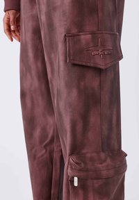 Bordeaux cargo broek met een gladde textuur, voorzien van een patchzak op de dij en ritselementen. Gegraveerd "PXP" logo op de zak.